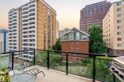 Private outdoor balcony featuring a glass and metal railing, concrete flooring, and surrounding urban buildings - #713 10503 98 Av Nw, Edmonton, AB - Outdoor With Balcony