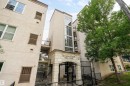 Stucco exterior featuring multiple stories, an arched stone entrance, and prominent glass window walls - #713 10503 98 Av Nw, Edmonton, AB  - Outdoor 