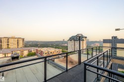 Rooftop walkway with black metal and glass panel railings - 