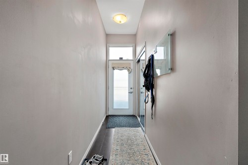 Entryway featuring a white door with upper window, dark wood-finish flooring, light grey painted walls, and a ceiling-mounted light fixture - #713 10503 98 Av Nw, Edmonton, AB - Indoor Photo Showing Other Room