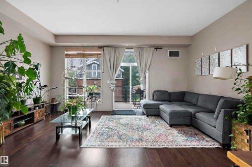 Spacious living area featuring dark wood-finish flooring, neutral wall tones, and recessed lighting - #713 10503 98 Av Nw, Edmonton, AB - Indoor Photo Showing Living Room