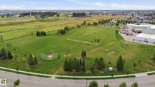 Expansive green space featuring a baseball diamond, multiple soccer goals, mature trees, and paved perimeter pathways - 1564 36 Avenue Nw, Edmonton, AB 