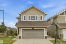 Two-story residential structure with a front-facing attached garage, concrete driveway, and front lawn - 1564 36 Avenue Nw, Edmonton, AB 