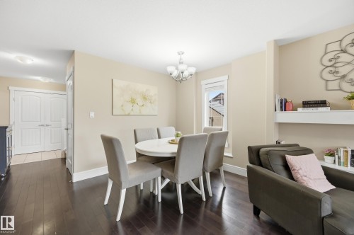 Dark wood-finish flooring throughout, white trim, and a built-in wall shelf - 1564 36 Avenue Nw, Edmonton, AB 