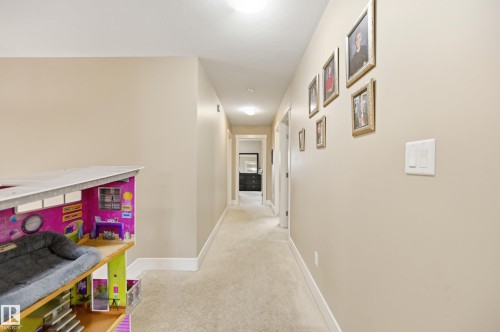 Recessed lighting illuminates the neutral-toned walls, contrasting with white trim and carpeted flooring - 1564 36 Avenue Nw, Edmonton, AB 