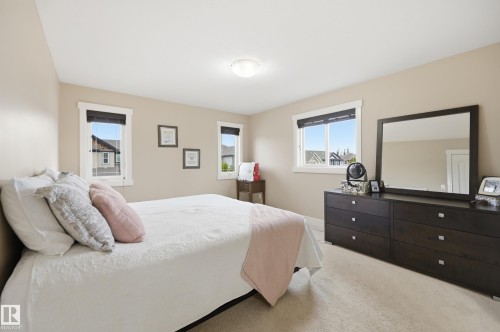 Neutral wall paint, light-toned carpeting, white trim windows, and a flush mount ceiling light fixture - 1564 36 Avenue Nw, Edmonton, AB 