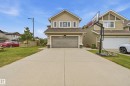 Two-story exterior with horizontal siding, attached garage, concrete driveway, and front lawn - 1564 36 Avenue Nw, Edmonton, AB 