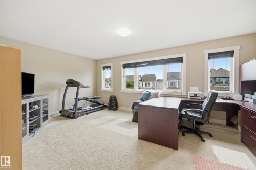 Expansive room featuring multiple windows, neutral wall tones, and carpeted flooring - 1564 36 Avenue Nw, Edmonton, AB 