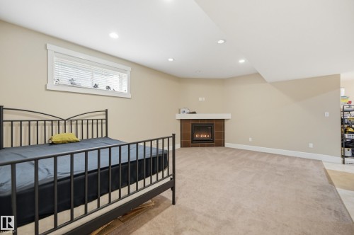 Recessed lighting, warm neutral wall tones, and a built-in fireplace with a tile surround and mantel - 1564 36 Avenue Nw, Edmonton, AB 