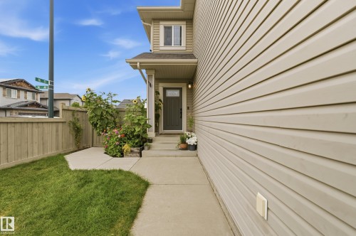 Light-toned horizontal siding with a concrete walkway leading to the entrance - 1564 36 Avenue Nw, Edmonton, AB 