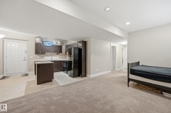 Integrated kitchenette with dark wood-finish cabinetry, light countertops, and built-in appliances - 