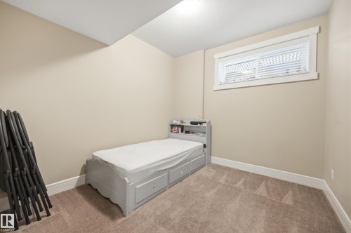 Carpeted room with a single window featuring white blinds and trim - 1564 36 Avenue Nw, Edmonton, AB 