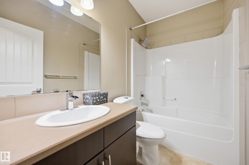 Recessed vanity with an integrated sink, polished chrome faucet, and a large wall-mounted mirror - 1564 36 Avenue Nw, Edmonton, AB 