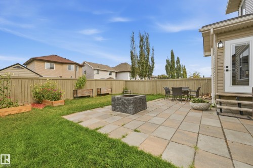 Paver patio with a stone fire pit and mature trees - 1564 36 Avenue Nw, Edmonton, AB 