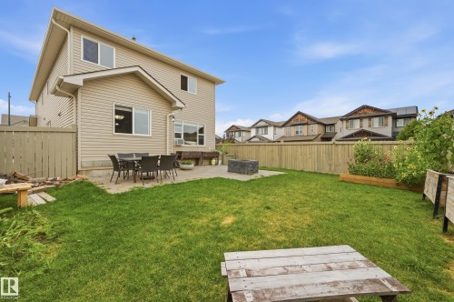 Expansive backyard featuring a manicured lawn, full privacy fencing, and a concrete patio - 1564 36 Avenue Nw, Edmonton, AB 
