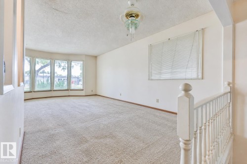 Bay window with multiple panes, ceiling fan, carpeted flooring, and white painted railing - 9 Hawkins Crescent, Sherwood Park, AB 
