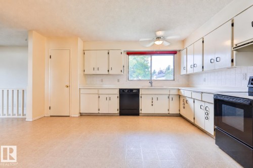 Kitchen featuring white cabinetry, white countertops, built-in dishwasher, built-in oven with cooktop, and a ceiling fan - 9 Hawkins Crescent, Sherwood Park, AB 
