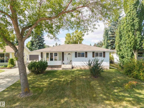 Single-story residence with white siding and brown shutters, featuring a bay window and an attached garage - 9 Hawkins Crescent, Sherwood Park, AB 