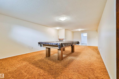 Spacious recreation room featuring light-colored walls and carpet flooring - 9 Hawkins Crescent, Sherwood Park, AB 