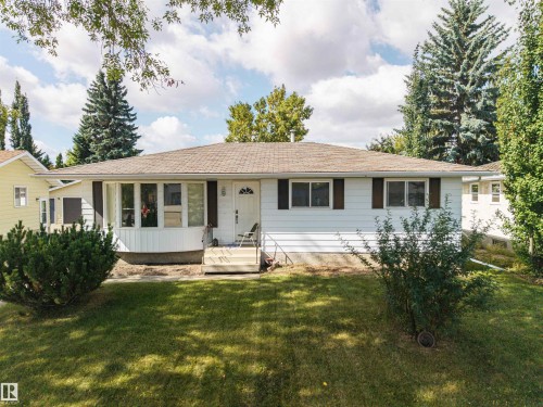 White siding exterior with a brown shingle roof, complemented by dark window shutters - 9 Hawkins Crescent, Sherwood Park, AB 