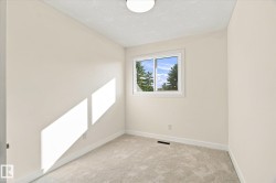 Neutral-toned walls with a white trim, carpeted flooring, and a single window - 