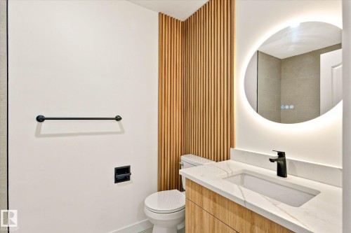 Modern vanity with wood-finish cabinetry, integrated rectangular sink, and light-toned countertop - 17325 85 Avenue Nw, Edmonton, AB 