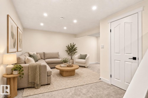 Recessed lighting illuminates this bright living space, featuring neutral wall tones and a paneled interior door with matte black hardware - 17325 85 Avenue Nw, Edmonton, AB 