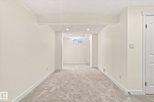 Recessed lighting illuminates neutral walls and light-toned carpeting - 17325 85 Avenue Nw, Edmonton, AB 