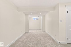 Recessed lighting illuminates neutral walls and light-toned carpeting - 