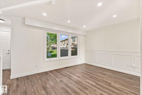 Wood-finish flooring, recessed ceiling lighting, three pane window, crisp white walls, and decorative wall molding - 17325 85 Avenue Nw, Edmonton, AB 
