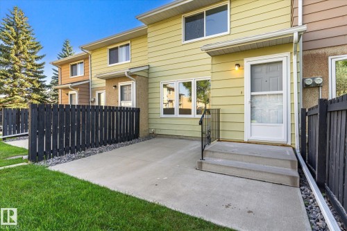 Concrete patio with a black picket fence and manicured lawn - 17325 85 Avenue Nw, Edmonton, AB 