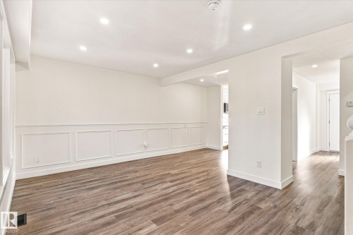 Recessed lighting illuminating the room, wood-finish flooring, and white paneled wainscoting - 17325 85 Avenue Nw, Edmonton, AB 