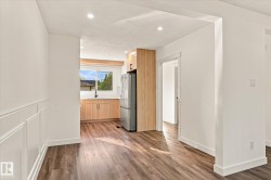 Wood-finish flooring, recessed lighting, and white wainscoting - 
