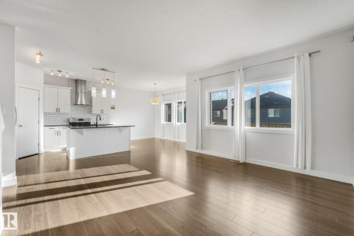 Expansive open-concept living space with wood-finish flooring - 7832 Erasmus Wynd Nw, Edmonton, AB 