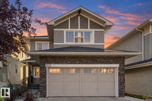 Stone veneer facade with an integrated two-car garage - 7832 Erasmus Wynd Nw, Edmonton, AB 