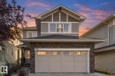 Stone veneer facade with an integrated two-car garage - 7832 Erasmus Wynd Nw, Edmonton, AB 