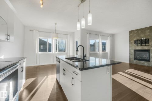 Kitchen island with black countertop and undermount sink - 7832 Erasmus Wynd Nw, Edmonton, AB 