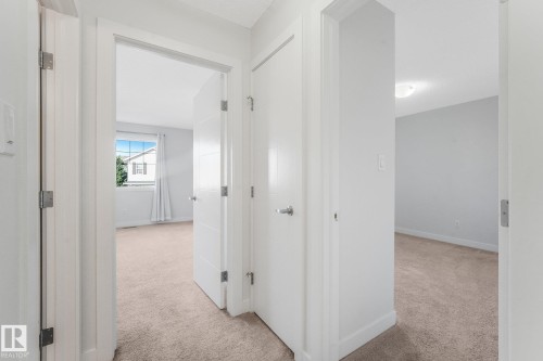 Carpeted flooring throughout, white interior doors, and neutral wall paint - 7832 Erasmus Wynd Nw, Edmonton, AB 