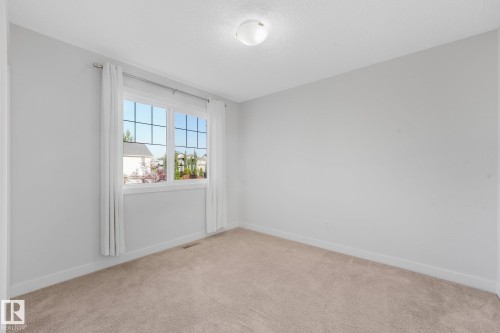 Light-colored carpeting, white baseboards, and a window with white trim - 7832 Erasmus Wynd Nw, Edmonton, AB 