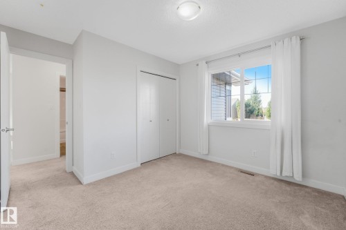 Neutral carpeting, white walls, and a multi-pane window with white trim - 7832 Erasmus Wynd Nw, Edmonton, AB 