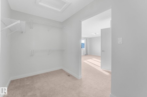 Walk-in closet with wire shelving system and neutral carpeting - 7832 Erasmus Wynd Nw, Edmonton, AB 