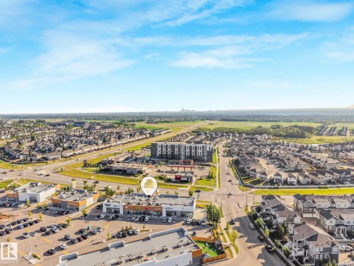 Mixed-use development with retail and residential structures, multiple vehicular intersections, and surface parking areas - 7832 Erasmus Wynd Nw, Edmonton, AB 