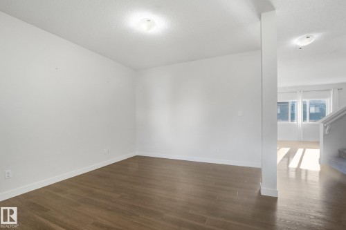 Wood-finish flooring with white baseboards throughout - 7832 Erasmus Wynd Nw, Edmonton, AB 