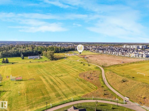 Expansive green spaces featuring walking paths, sports fields, and a distant residential community - 7832 Erasmus Wynd Nw, Edmonton, AB 