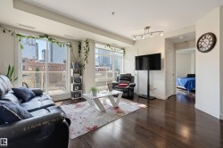 Open-concept living area featuring dark wood-finish flooring, white walls, and track lighting - 