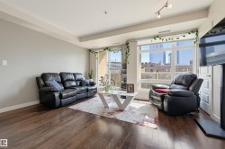 Living area featuring rich wood-finish flooring, light grey walls, and track lighting - 