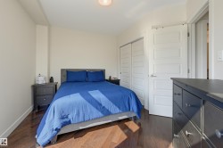 Bedroom featuring wood-finish flooring, light-toned walls, and a closet with bifold doors - 