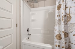 White fiberglass shower and bathtub combination with a rain shower head and brushed nickel fixtures - 