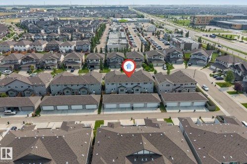 Aerial perspective showcasing a residential development with multiple detached homes and townhomes, characterized by consistent architectural styling and dark shingle roofing - 1514 26 Avenue Nw, Edmonton, AB - Outdoor With View