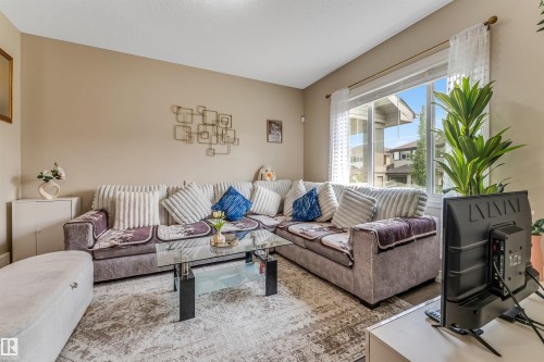 Spacious living area featuring light-toned walls, wood-finish flooring, and a large picture window providing ample natural light - 1514 26 Avenue Nw, Edmonton, AB - Indoor Photo Showing Living Room